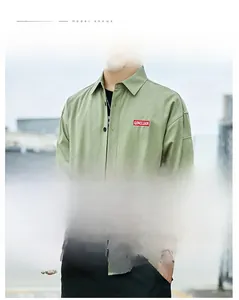 Detail of green workwear shirt showing utility sleeve pocket and turn-down collar