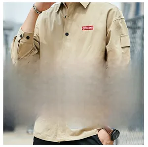 Detail of khaki cotton shirt featuring red woven chest label and side arm pocket design