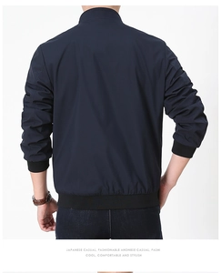 Detail of navy blue reversible jacket showing ribbed cuffs and standing collar back view