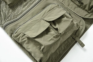 Détail du gilet utilitaire vert militaire avec multiples poches et doublure en maille