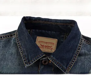 Macro shot of dark blue denim collar with vintage label and yellow double-stitching