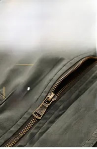 Detail of durable military green cotton jacket fabric with vintage bronze metal zipper