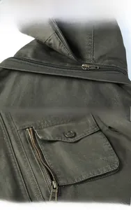 Detail of army green jacket featuring detachable hood and multi-pocket functional design