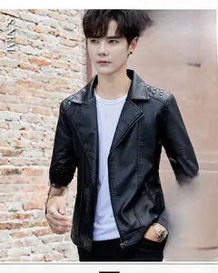 Detail of men's biker leather jacket featuring asymmetric zipper and rivet shoulder studs