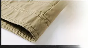 Detail of khaki cotton jacket showing fine parallel stitching and high-density fabric