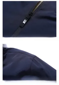 Detail view of smooth zipper and reinforced shoulder stitching on the dark blue jacket