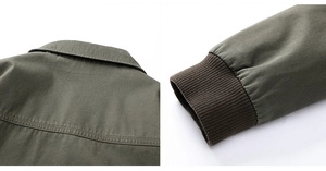 Detailed view of double-stitched collar and ribbed knit cuffs on olive cotton cargo jacket