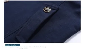 Dettaglio della tasca laterale di un cappotto blu scuro con bottone metallico corona vintage