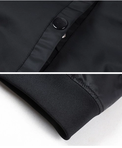 Detail of glossy snap buttons and ribbed cuffs on black MA1 pilot bomber jacket