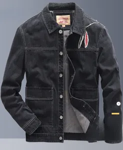 Detail of black denim jacket featuring red and gray feather embroidery and metal buttons