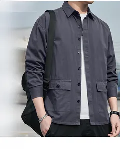 Detail of dark gray cotton workwear shirt featuring buttoned chest pockets and durable fabric