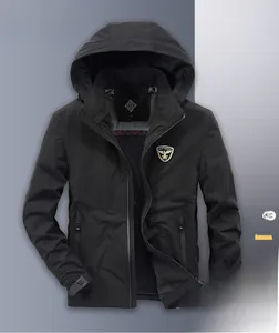 Detail of outdoor hooded windbreaker featuring a brand logo shield and adjustable cuffs