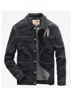 Detail of black denim jacket featuring silver buttons and feather embroidery on the chest