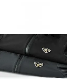 Macro shot of embroidered eagle shield logo and matte waterproof zipper on men's jacket