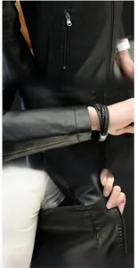 Detail view of black PU leather jacket showing zip pockets, cuffs and interior pocket