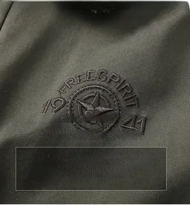 Detail of dark olive twill fabric with star and FREESPIRIT embroidery on a men's jacket