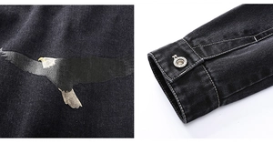 Detail of eagle print and silver metal buttons on black denim jacket with white stitching