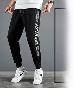 Détail d'un jogging noir coupe slim avec texte grunge blanc et taille à cordon