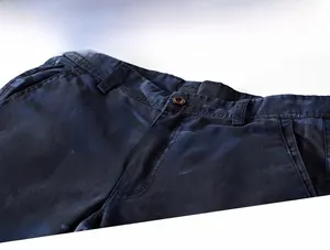Close-up of camouflage cargo shorts showing zipper fly, button closure and reinforced stitching