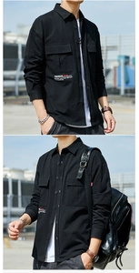 Detail of black cotton work shirt showing chest flap pockets and white graphic text print