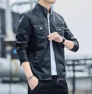 Detailed view of black faux leather jacket with metal zippers and textured grain