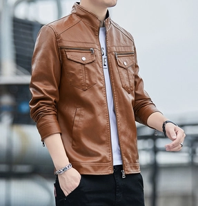 Detail shot of brown leather moto jacket showing multiple pockets and stitching texture