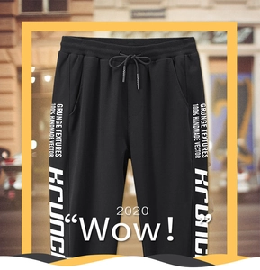 Détail du jogging noir avec impression de texte blanc sur le côté et cordon de serrage