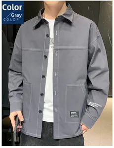 Detail of grey utility shirt featuring white contrast stitching and chest pockets
