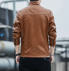 Detail view of the back of a slim fit men's caramel brown faux leather jacket with seams