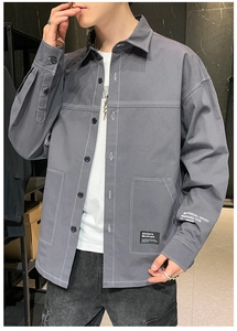 Detail of grey workwear shirt featuring white contrast stitching and utility pockets