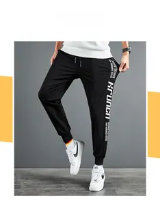 Détail du jogging noir ajusté pour hommes avec imprimé lettrage blanc et cordon de serrage