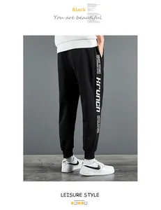 Détail d'un pantalon de jogging noir avec imprimé graphique blanc sur le côté