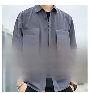 Close-up of gray cotton shirt featuring twin chest pockets and fine twill fabric details