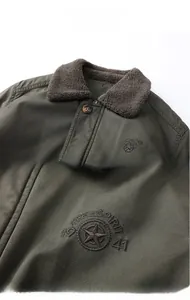 Detail of army green jacket collar with warm fleece lining and star embroidery logo