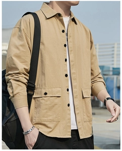 Close-up detail of khaki utility shirt with dual flap pockets and cotton fabric texture