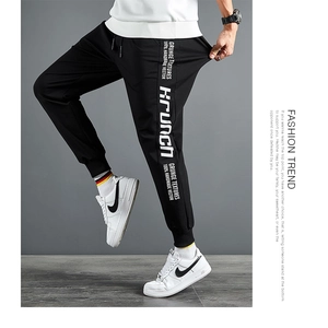 Détail du jogging en coton noir montrant l'imprimé Krunch et la taille élastique réglable