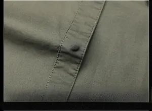 Macro shot of fashion button on army green cotton shirt with double-needle stitching