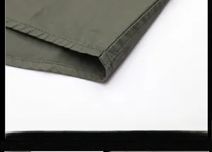 Macro shot of double-stitched hem on a men's army green cotton utility shirt
