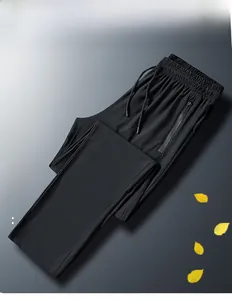 Detail of men's black ice silk pants featuring zipper pockets and elastic drawstring waist