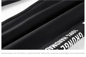 Détail du pantalon en coton noir montrant la texture de sérigraphie grunge blanche