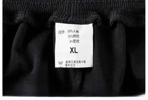 Détail de la taille élastique et étiquette d'entretien du pantalon en coton mélangé