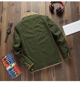 Dettaglio della giacca da uomo verde militare con calda fodera in pile su parquet scuro