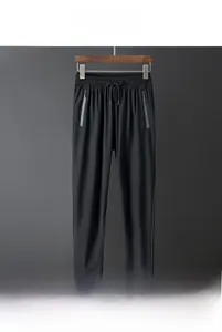 Detail of men's summer ice silk pants showing elastic drawstring waist and zip pockets