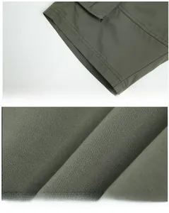 Detail of army green cotton twill shorts showing durable fabric texture and double-stitched hem