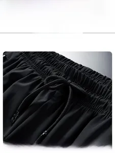 Detail of black sports trousers featuring an elastic waistband with adjustable drawstrings