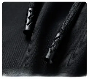 Detail of black drawstring with textured aglet on casual sporty ice silk pants