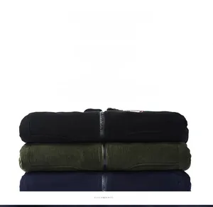 Detail of stacked corduroy winter jackets in black, olive green and navy blue colors