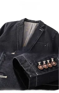 Detail show of black denim blazer featuring ginkgo leaf pattern lining and vintage cuff buttons
