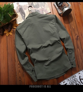 Camicia da uomo in cotone verde oliva con accessori vintage su fondo in legno