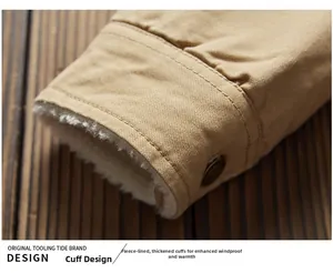 Detail of windproof khaki jacket cuff with thick white fleece lining and metal button